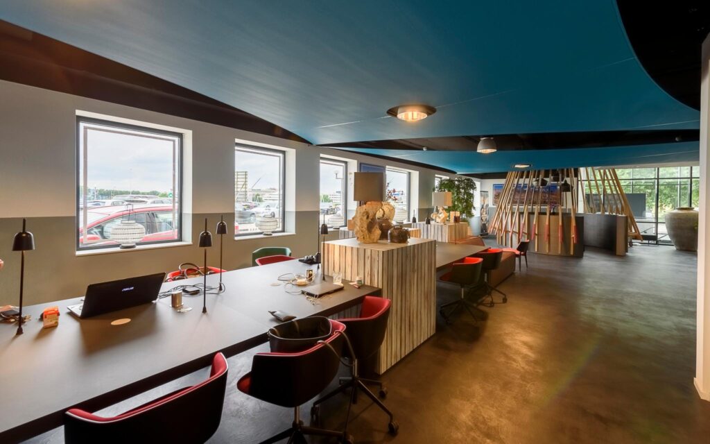 Moderne, open kantoorruimte in Rivium Quadrant met werkplekken, designmeubilair en grote ramen met uitzicht naar buiten.